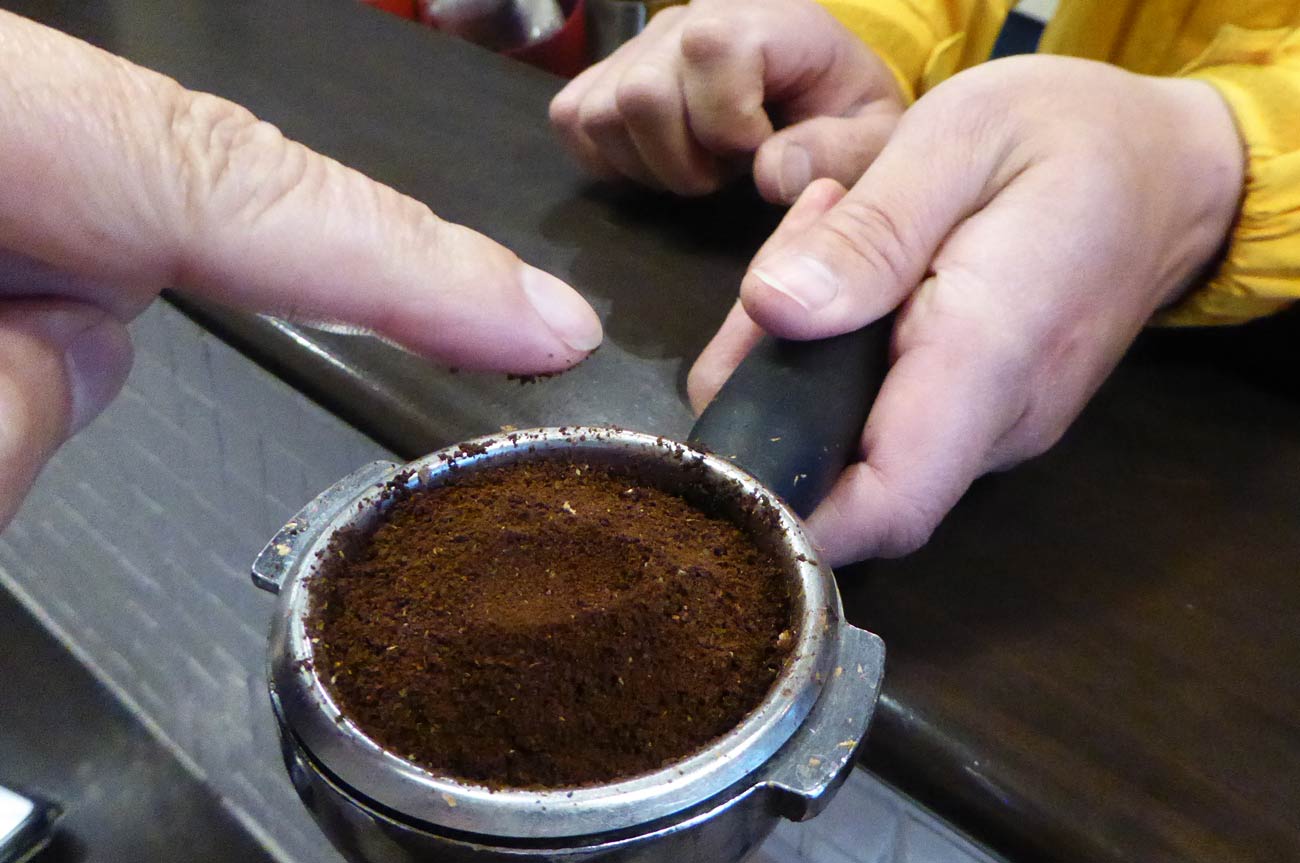 挽いたコーヒー豆を手で触る